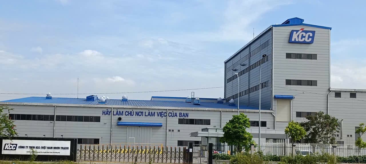 Nhà máy KCC (Việt Nam Nhơn Trạch) trong Khu công nghiệp Nhơn Trạch 6: nhà xưởng mái xanh và khối tháp cao mang logo KCC